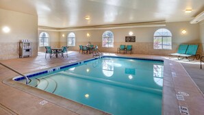 An indoor swimming pool with clear lane markings, a coffee station, and seating areas with tables and chairs. - Comfort Inn Evansville - Casper (Evansville)