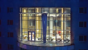 A modern building with a large, illuminated window and a balcony. - Park Plaza Beijing Science Park (Beijing)