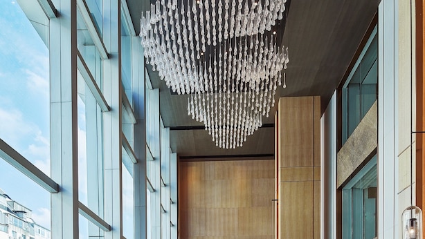 A modern hotel lobby with a high ceiling, large windows, and a central seating area with tables and chairs. - Park Plaza Beijing Science Park (Beijing)