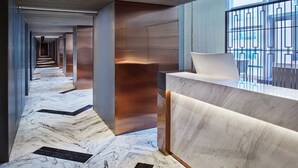A modern hotel lobby with a marble floor, a reception desk, and a view of the city through large windows. - Park Plaza Beijing Science Park (Beijing)
