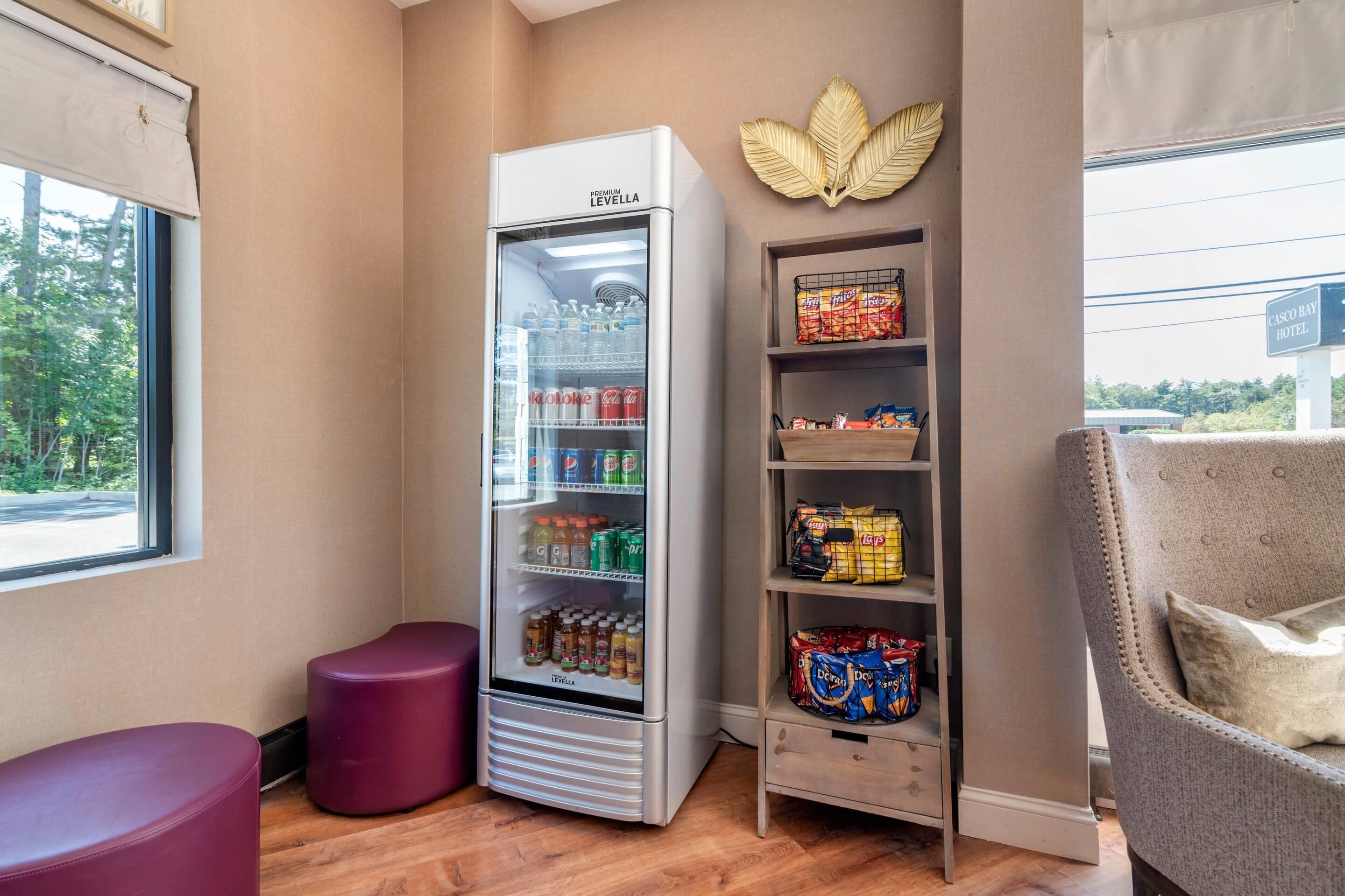 Habitación de hotel con minibar, zona de estar y vistas al exterior.