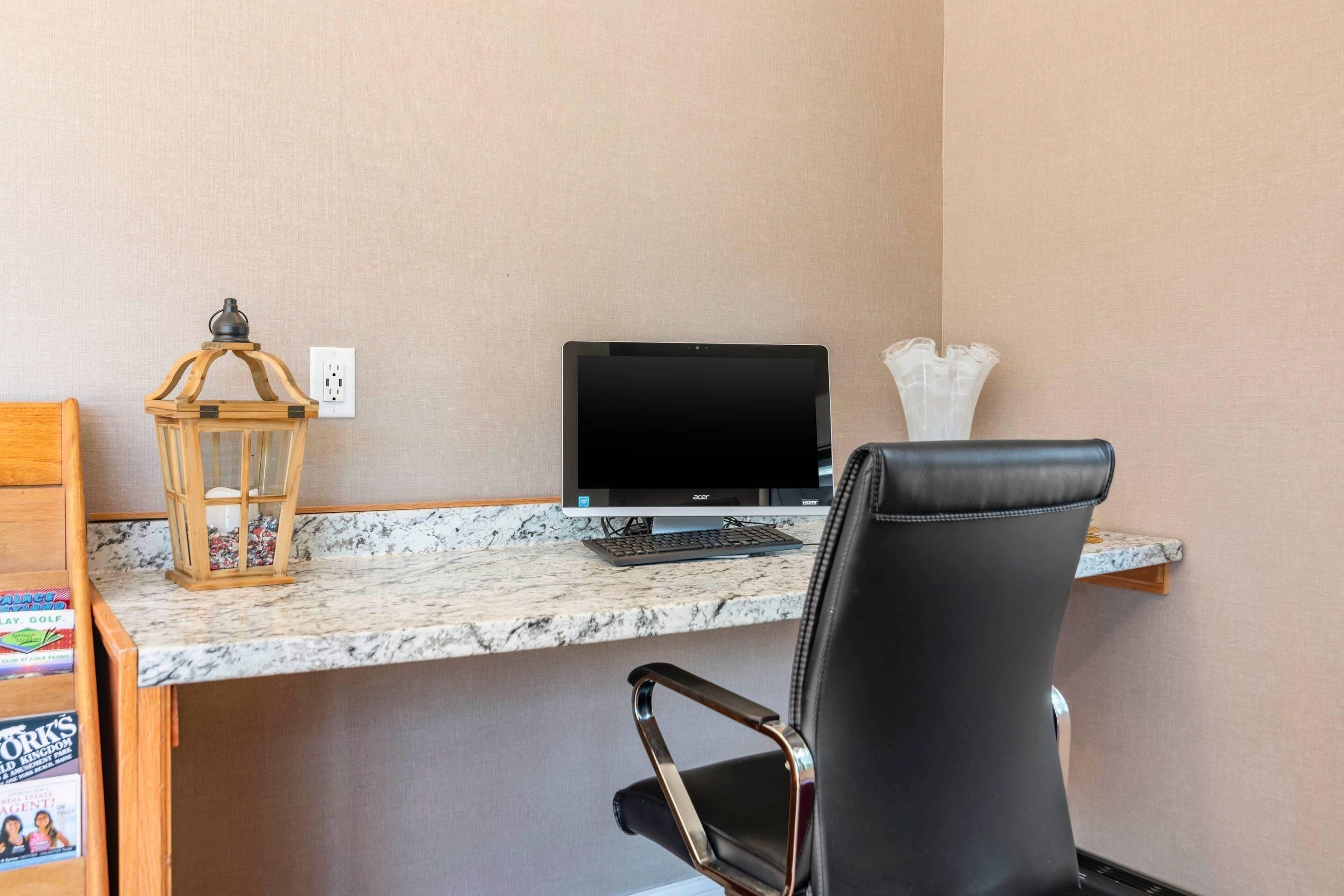 A workspace with a computer, a chair, a shelf with books, and a decorative lantern.