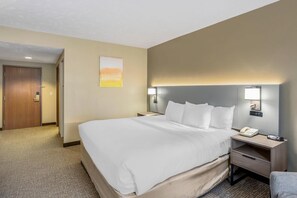 A hotel room with a large bed, bedside tables, a desk, and a phone. - Comfort Inn Huntingdon (Huntingdon)