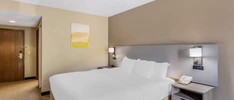Habitación de hotel con una cama grande, mesitas de noche, un teléfono y un cuadro en la pared.