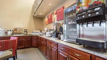 Una cocina equipada con cafetera, microondas y refrigerador.