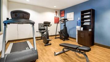 A gym with treadmills, stationary bikes, and a bench.