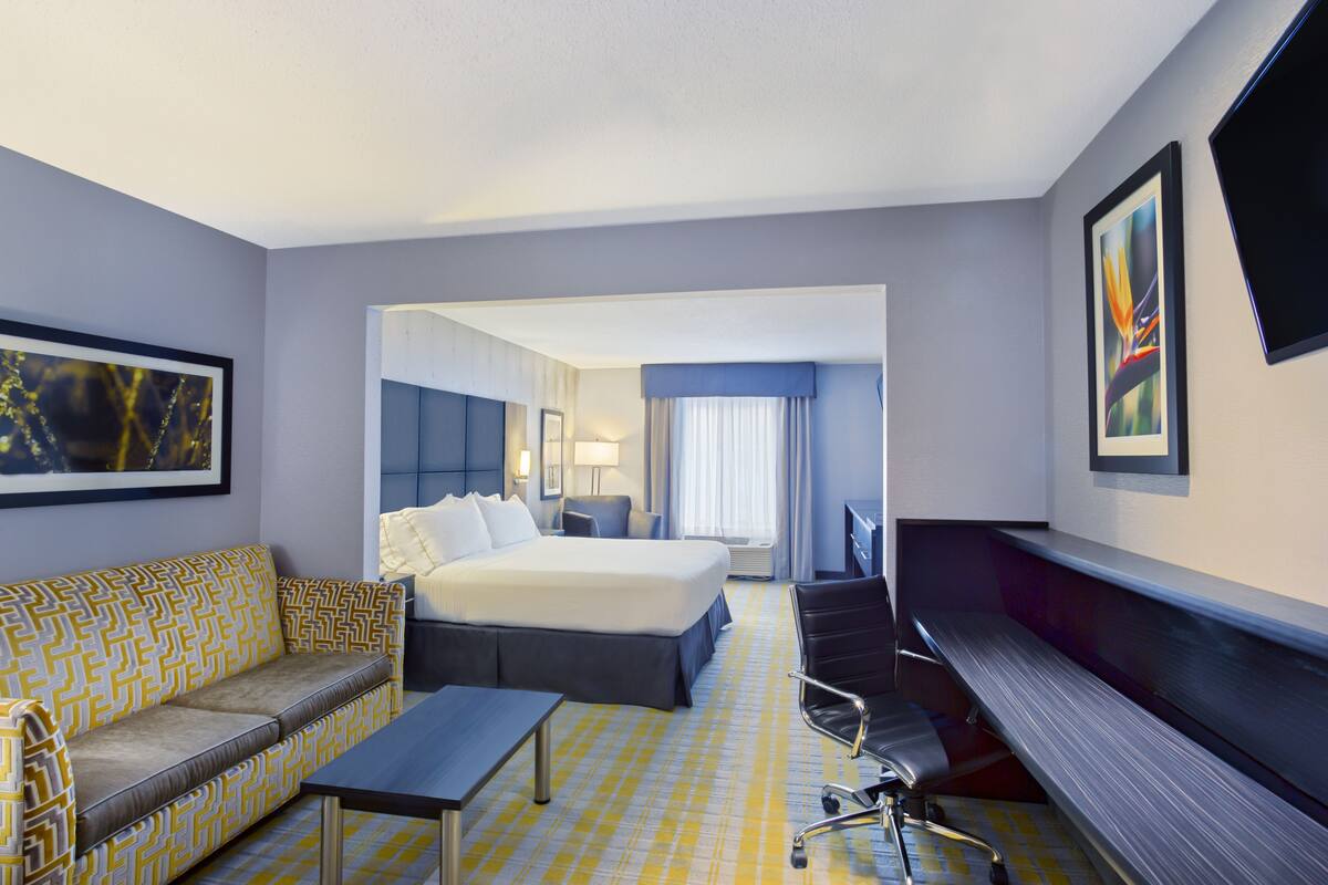 Ein Hotelzimmer mit Bett, Sofa, Schreibtisch und Stuhl.