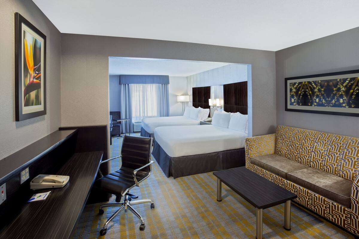 Ein Hotelzimmer mit Bett, Sofa, Schreibtisch und Stuhl.