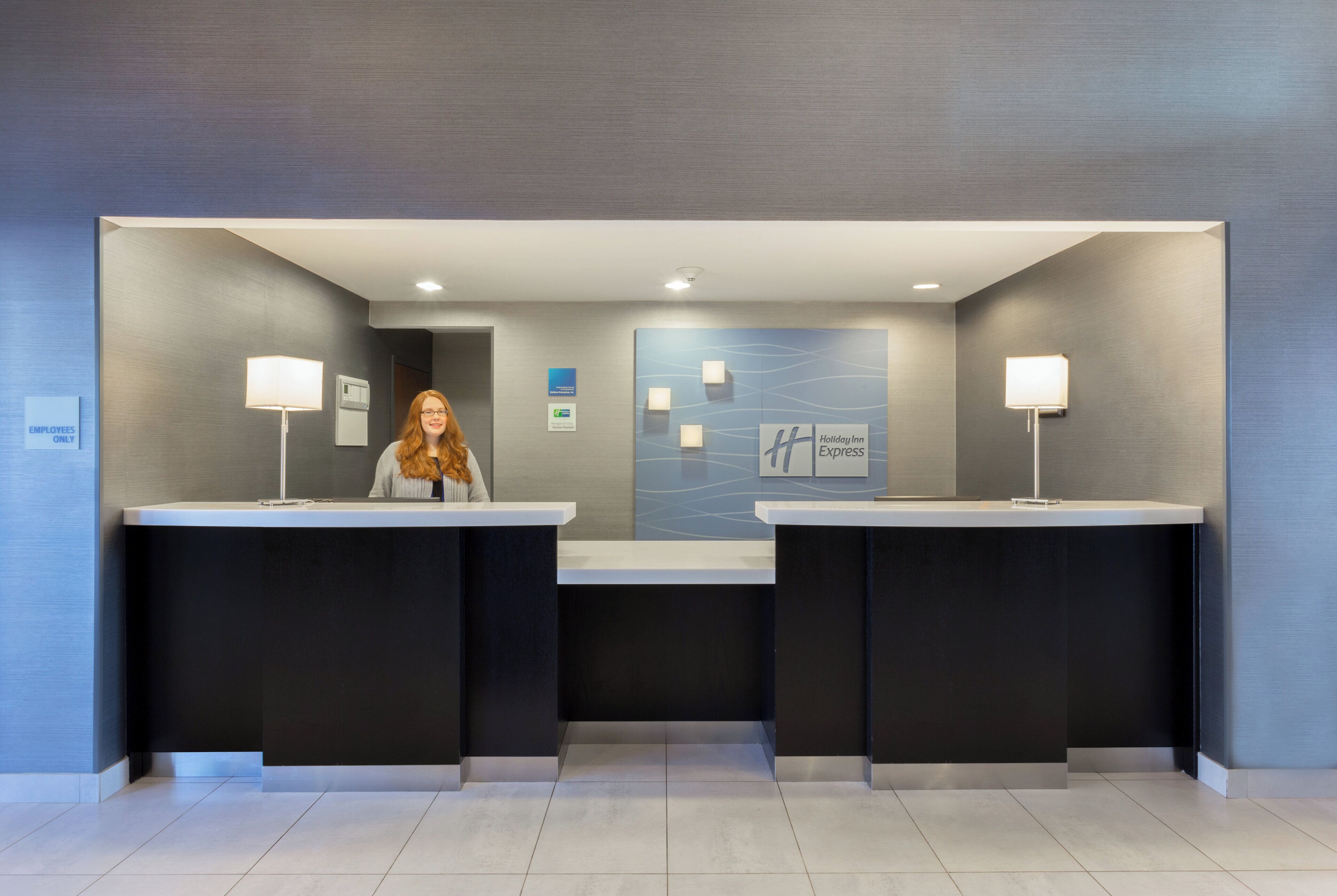 A reception area with two counters, a wall-mounted sign, and a floor plan.