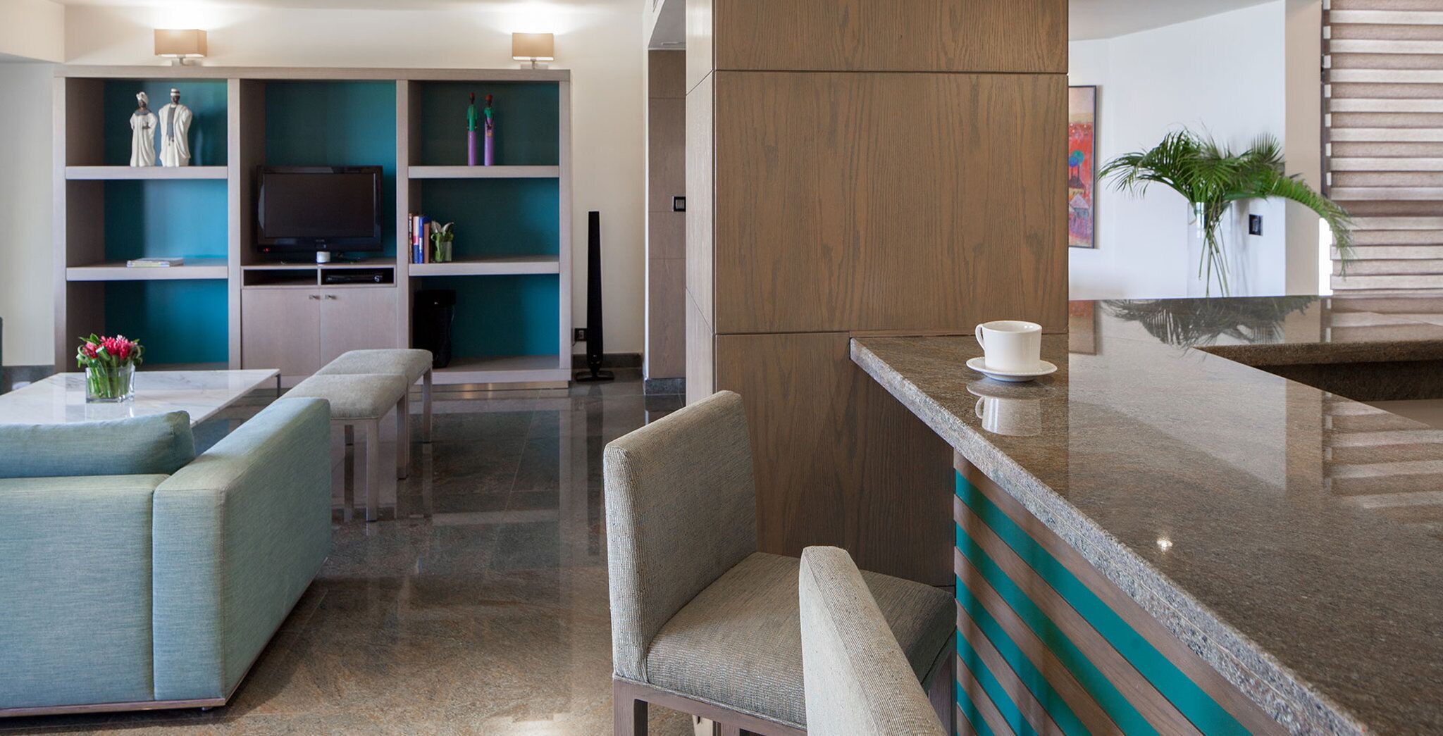 Un hall d’hôtel moderne doté d’un espace salon, d’un téléviseur et d’un comptoir d’accueil.