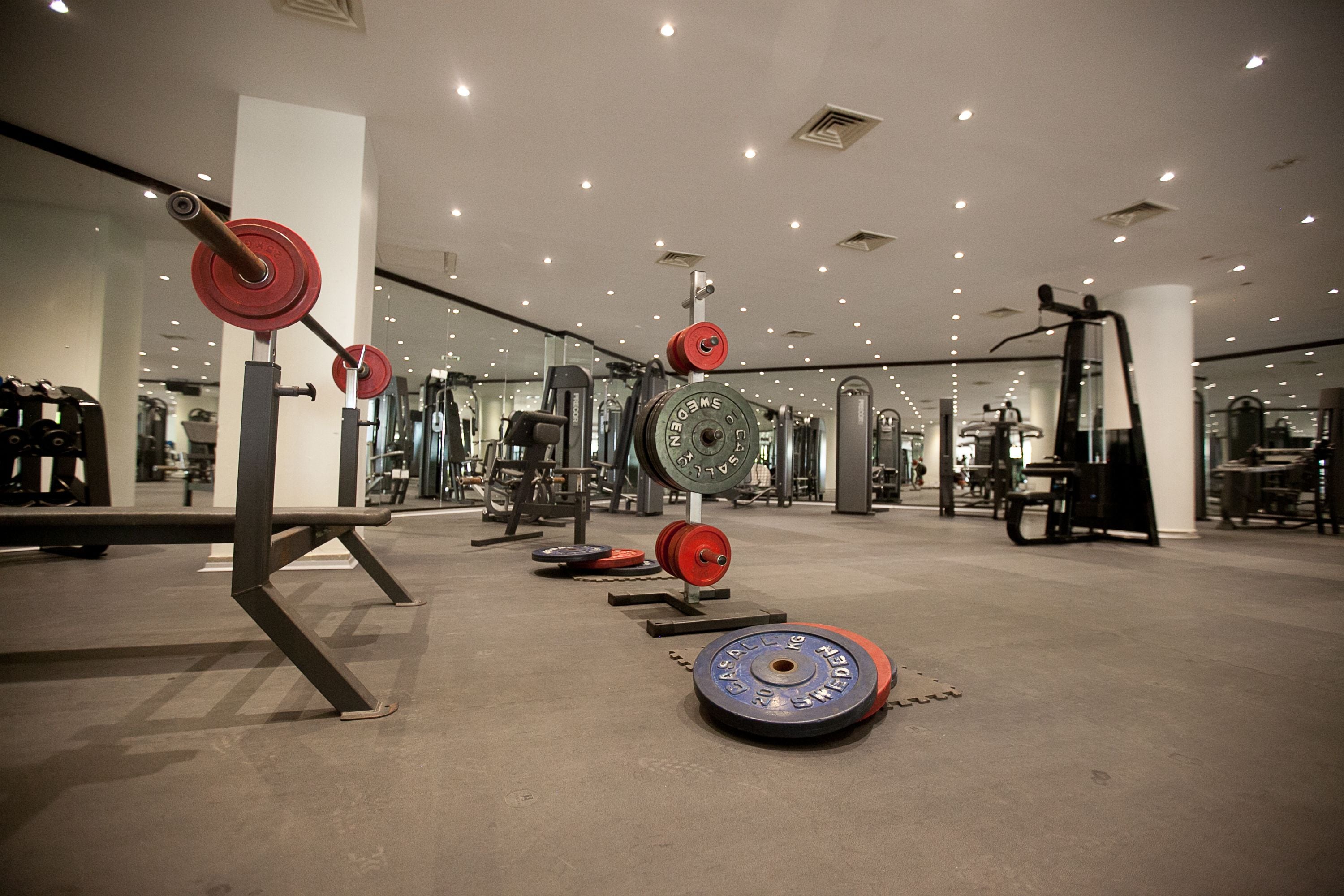 Une salle de sport équipée de matériel de musculation et de miroirs.