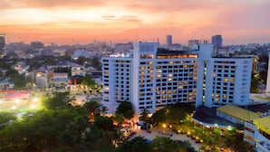 A multi-story hotel with a central courtyard, surrounded by other buildings. - Eko Hotel Main Building (Lagos)