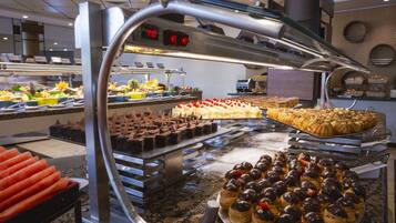 A buffet with various desserts and pastries, including chocolate tarts and cream puffs.
