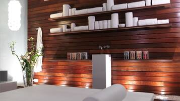 A modern bathroom with wooden paneling, a large mirror, and neatly arranged towels on shelves.