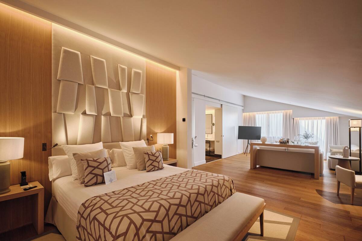 Une chambre d’hôtel moderne, dotée d’un grand lit, d’un bureau et d’un coin salon.