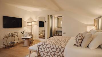 A modern bedroom with a large bed, bedside tables, a mirror, and a TV mounted on the wall.