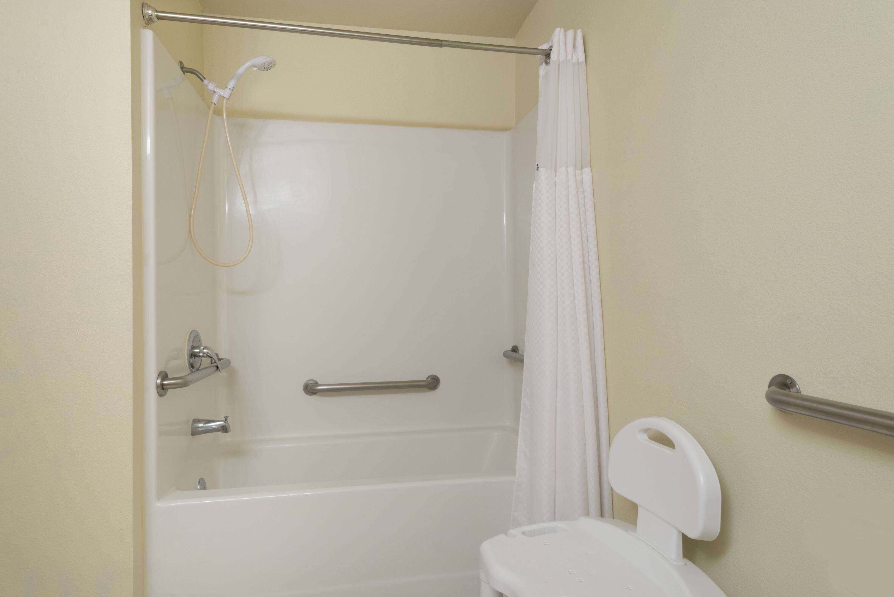 A bathroom with a bathtub, toilet, and shower curtain.