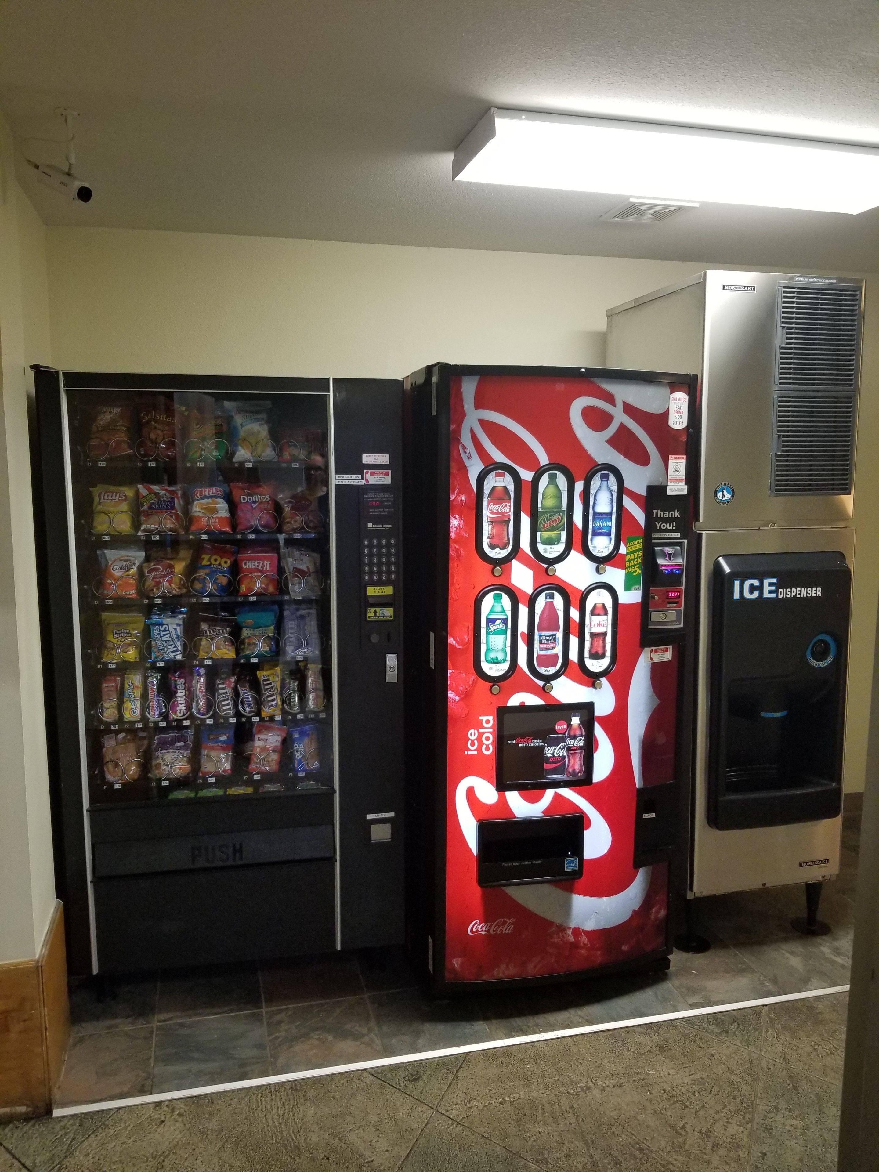A vending machine with snacks and a Coca-Cola dispenser.