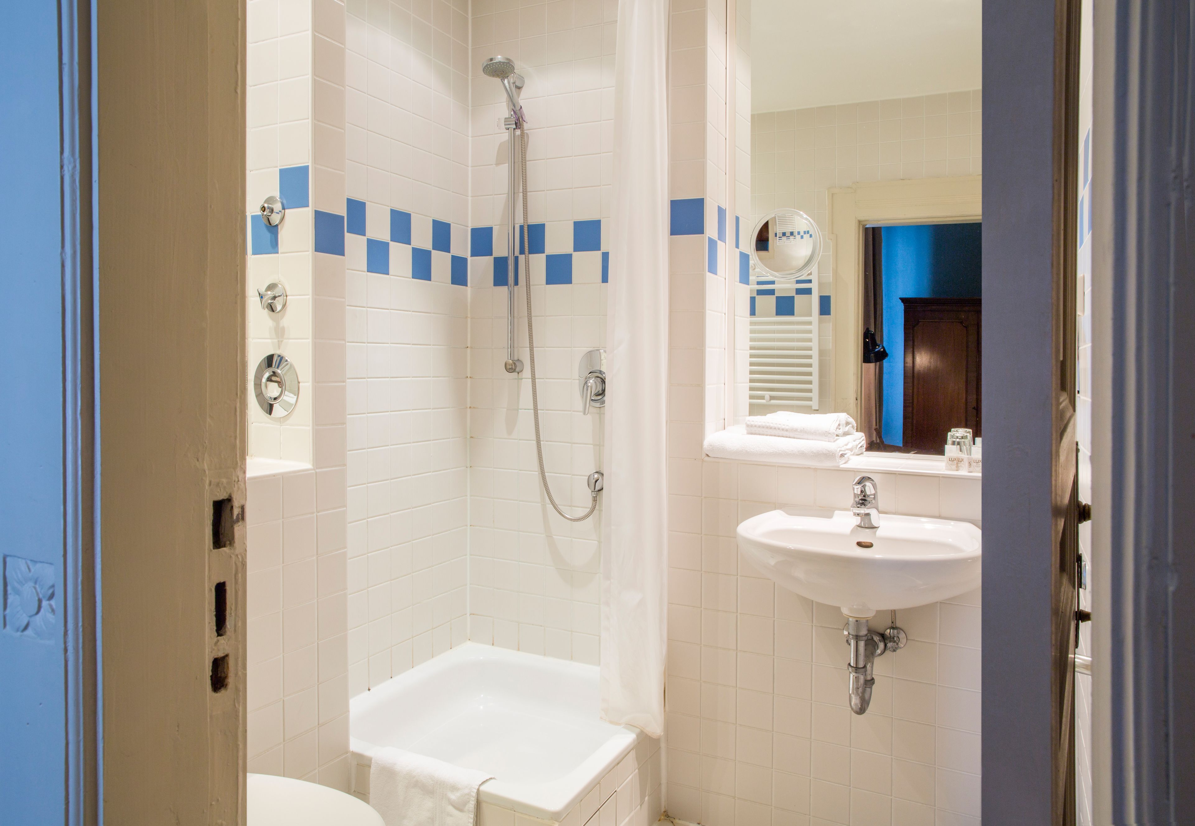 A bathroom with a shower, a sink, and a toilet.
