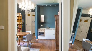 A kitchen with a built-in oven, a white cabinet, and a blue accent wall. - Hotel Art Nouveau (Berlin)