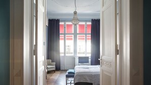 A bedroom with a bed, a chair, a desk, and a window with curtains. - Hotel Art Nouveau (Berlin)
