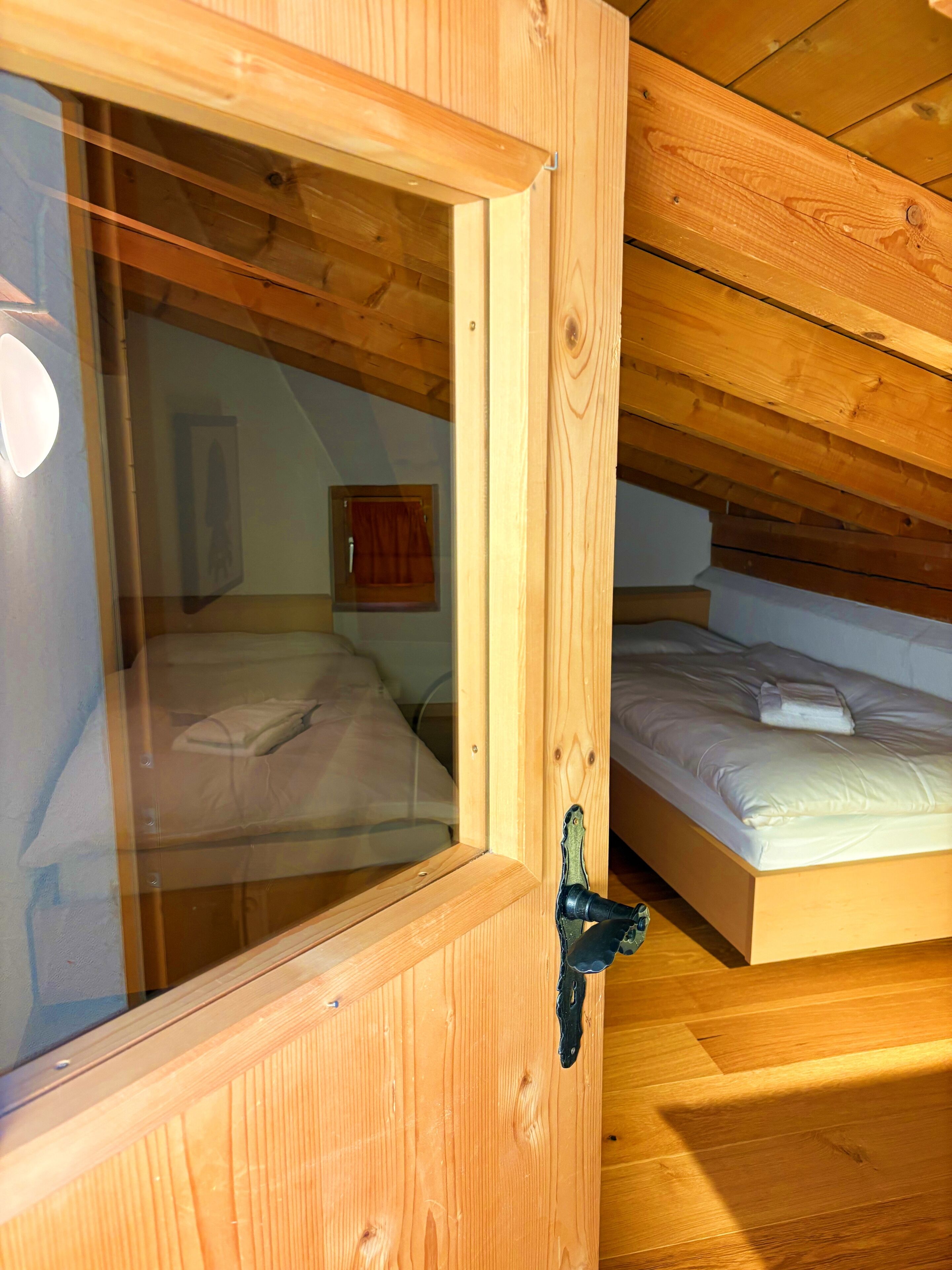 Una habitación de madera con una cama y un ventanal.
