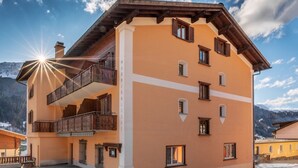 A multi-story hotel with balconies and a mountain backdrop. - Madrisa Lodge (Klosters-Serneus)