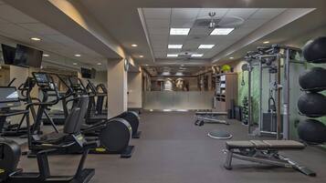 A gym with treadmills, weight machines, and a bench.