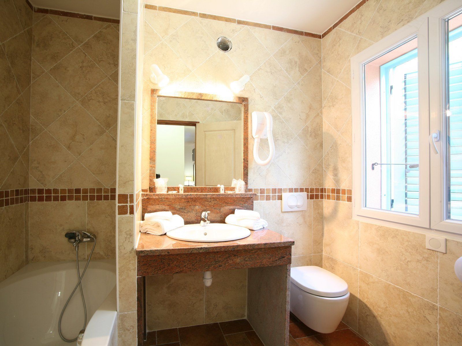 Un baño con lavamanos, espejo e inodoro.