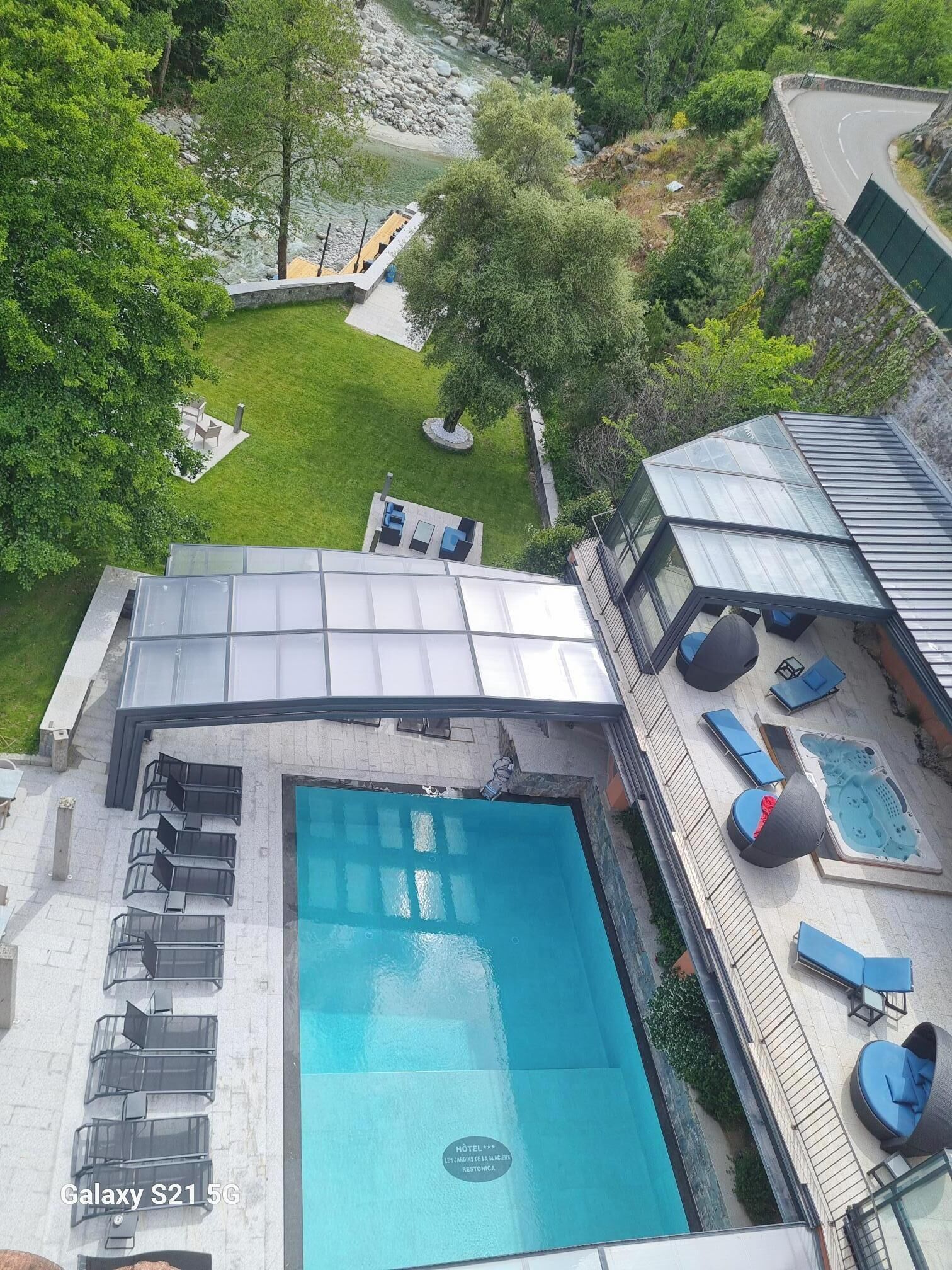 Une piscine sur le toit, dotée de chaises longues et d’une terrasse fermée par des baies vitrées.