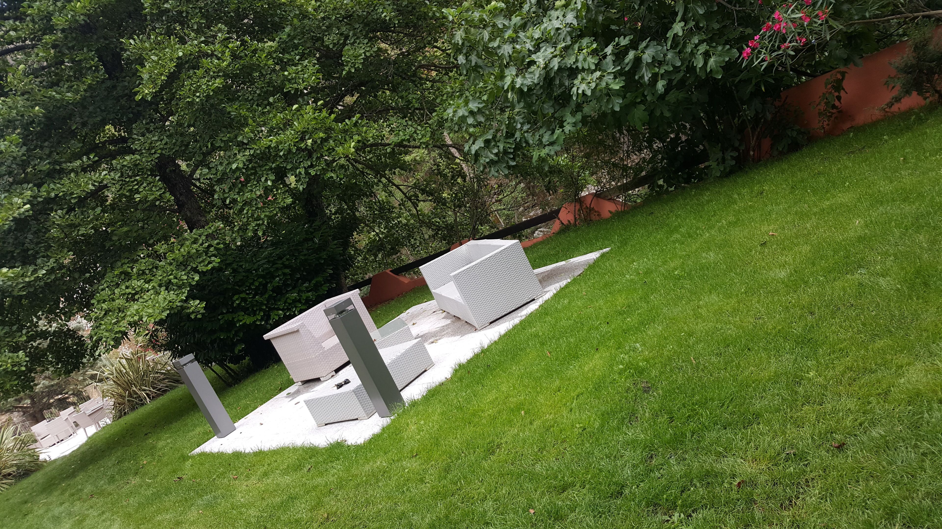 Un espacio al aire libre con césped y un conjunto de asientos blancos.