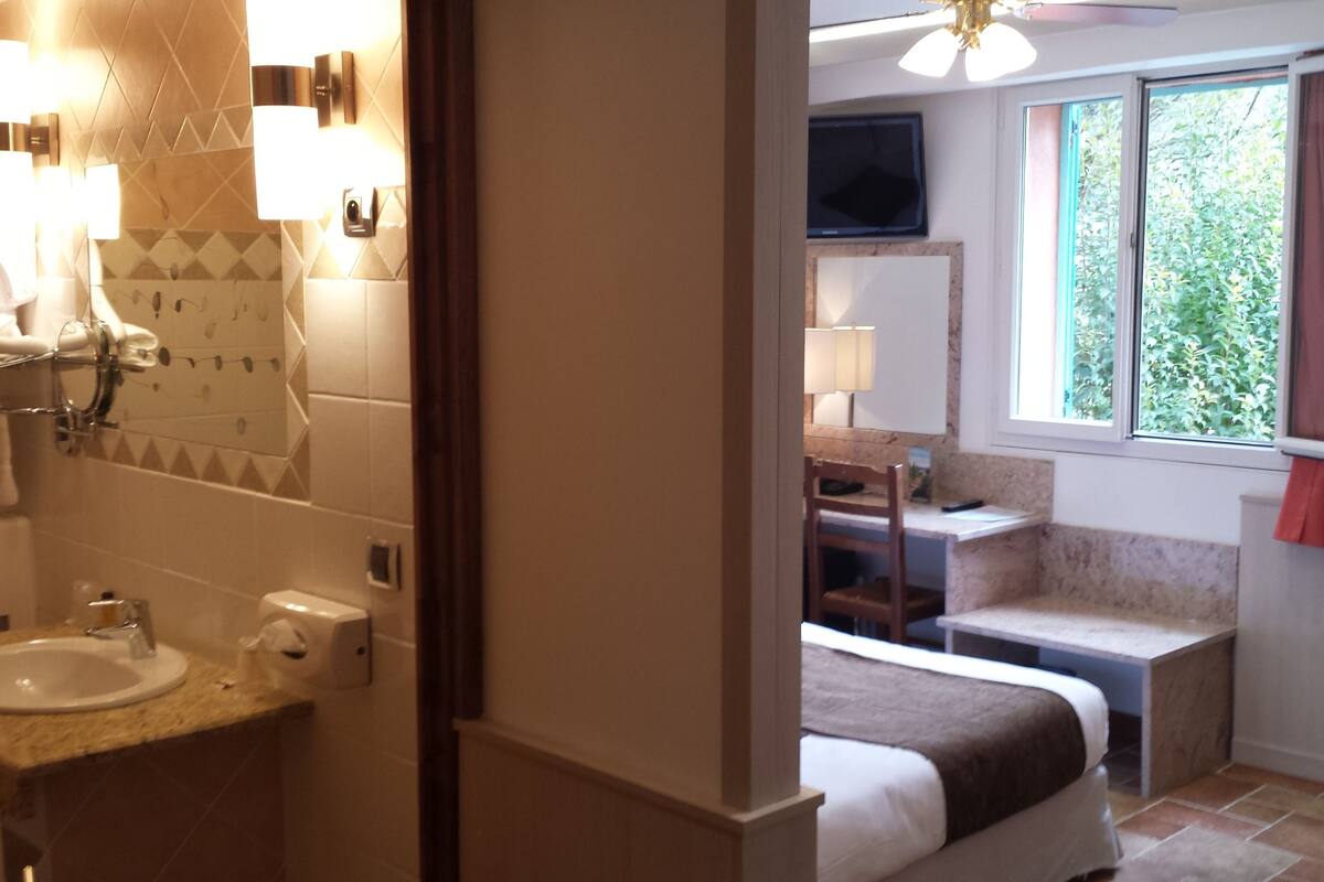 Un baño con lavamanos, espejo, toallero y cabina de ducha.