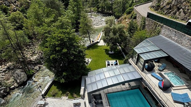 Hotel amb piscina, zona d'estar a l'aire lliure i vistes a un paisatge de muntanya.