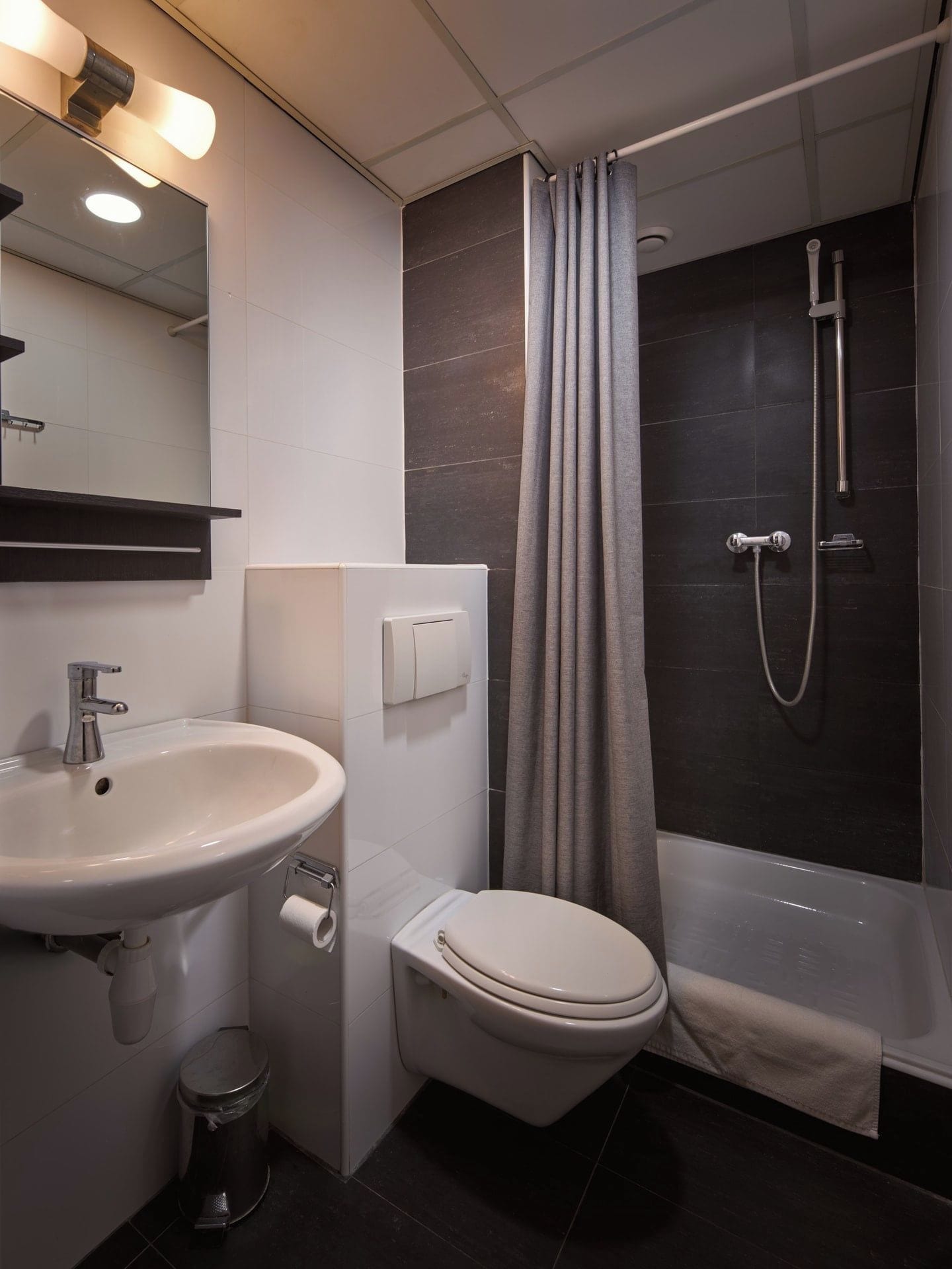 Un bagno moderno con lavandino, toilette e doccia.