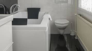 Un baño moderno con bañera, inodoro y lavamanos.