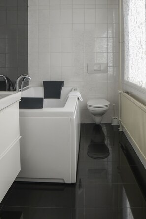A modern bathroom with a bathtub, toilet, and sink. - Hotel Zwanenburg (Zwanenburg)