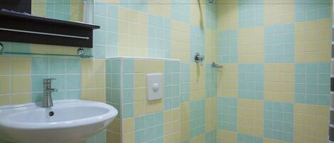 A bathroom with a sink, a shower, and a toilet.