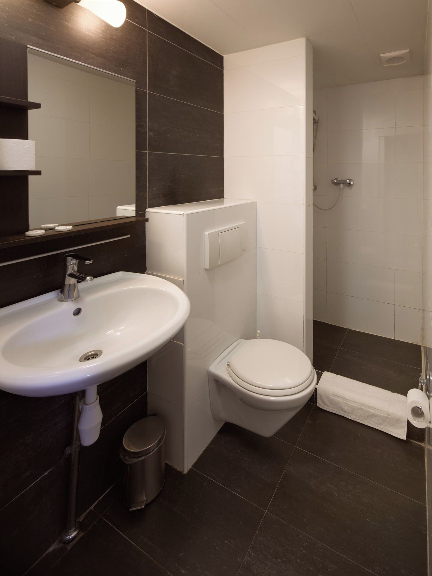 A modern bathroom with a white sink, toilet, and shower.