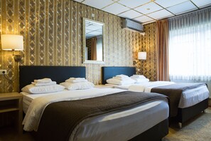 A hotel room with two beds, a large mirror, and patterned wallpaper. - Hotel Zwanenburg (Zwanenburg)