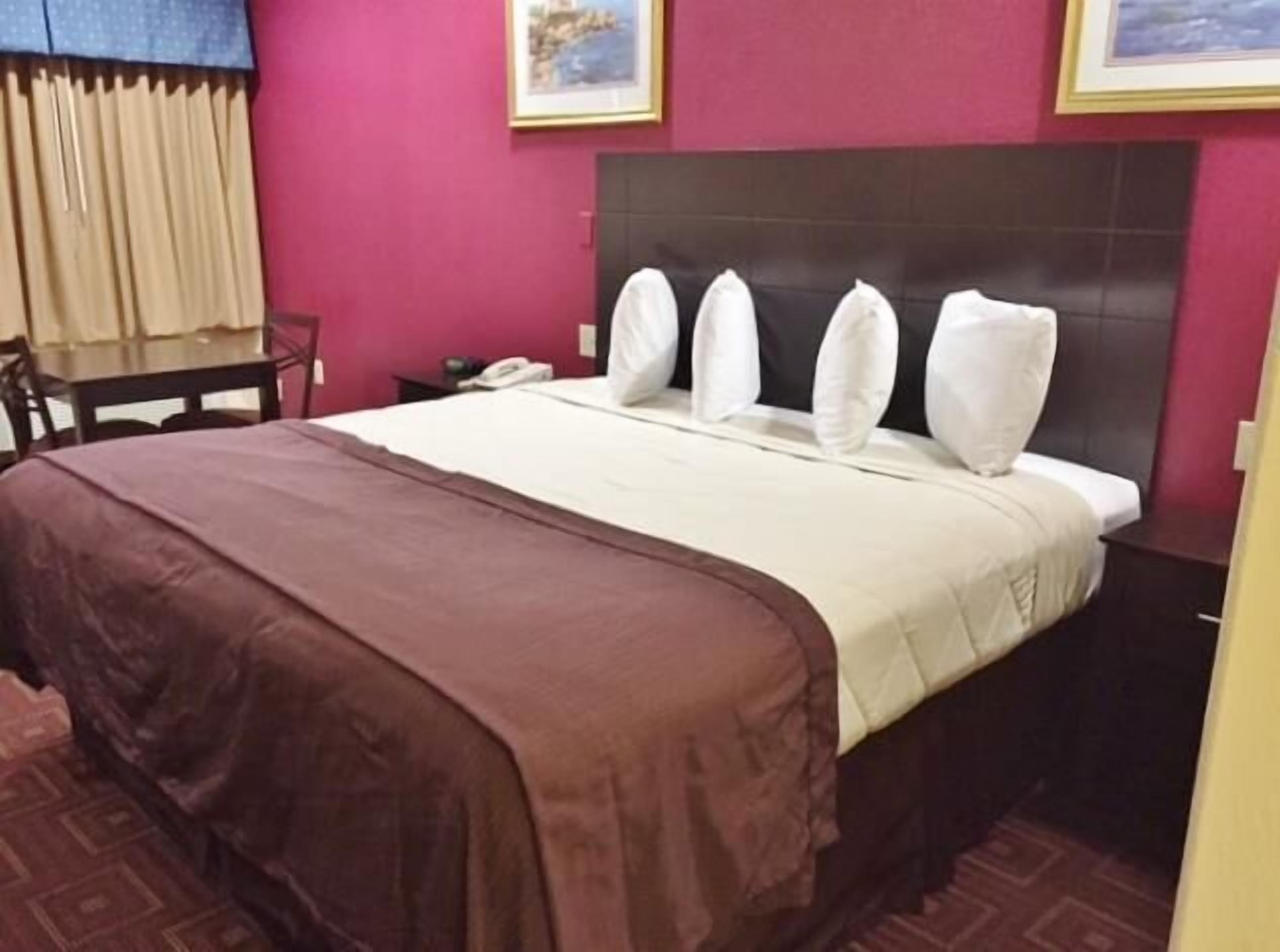 Een hotelkamer met een bed, een bureau en een stoel.