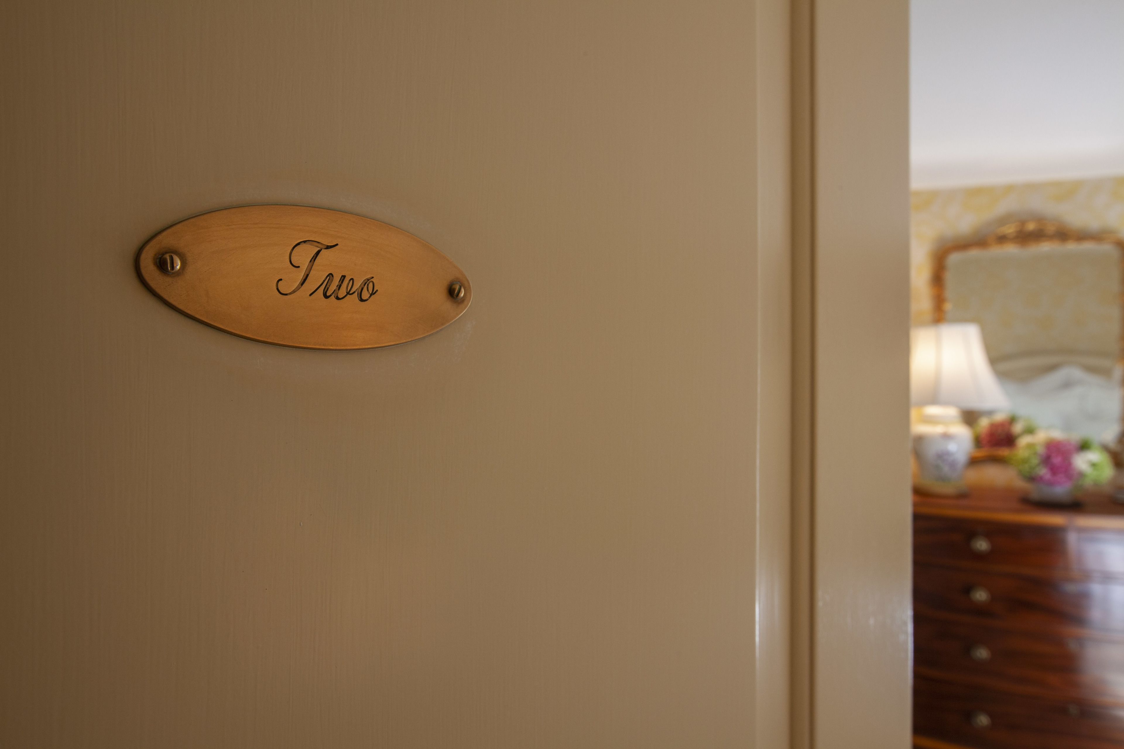 Una placa de madera en una puerta con el nombre "TWO" grabado.