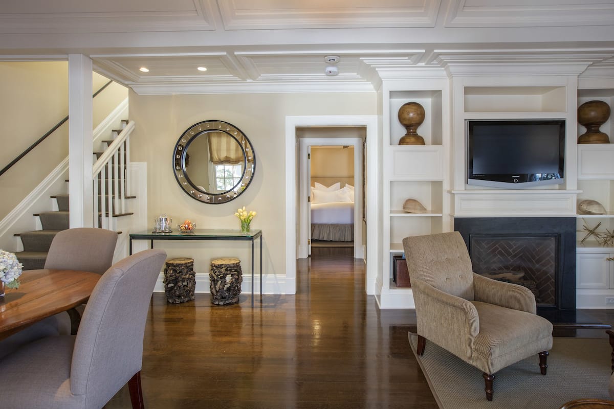 A living room with a fireplace, a television, and a staircase.