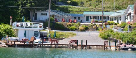 A lakeside motel with outdoor seating and a dock.