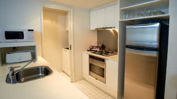 A modern kitchen with a microwave, toaster, sink, stove, oven, and refrigerator.
