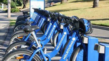 A row of blue bicycles with 'Melbourne' branding, parked in a designated area.