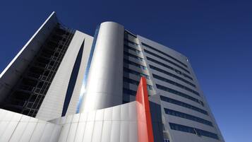 Un edificio moderno con una sección cilíndrica destacada y una estructura alta y angular.