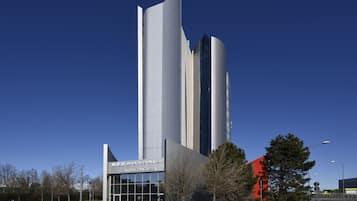 Een modern hotelgebouw met een uniek architectuurontwerp, gekenmerkt door een opvallend verticaal element en een glazen gevel.