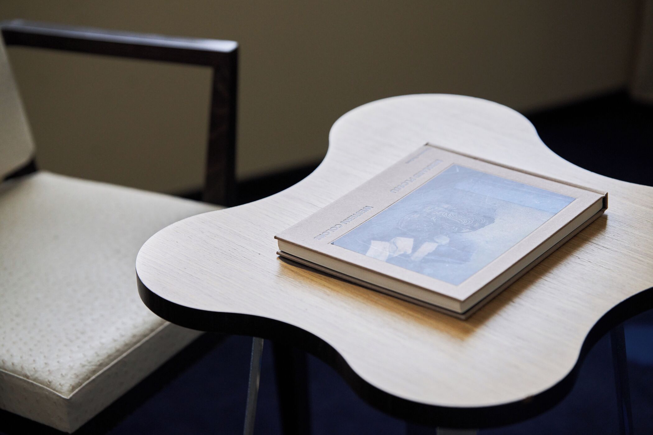 Un libro sobre una mesa de madera de forma singular.