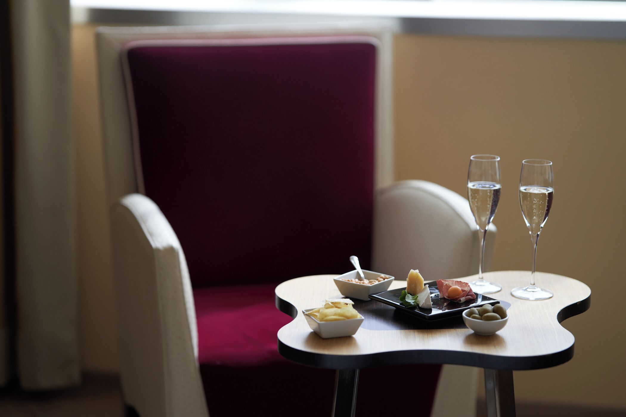 Ein Esstisch mit einer Dessertplatte, zwei Champagnergläsern und einer Oliven-Schale.