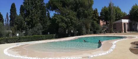 Alberca al aire libre por temporada y sombrillas en la alberca